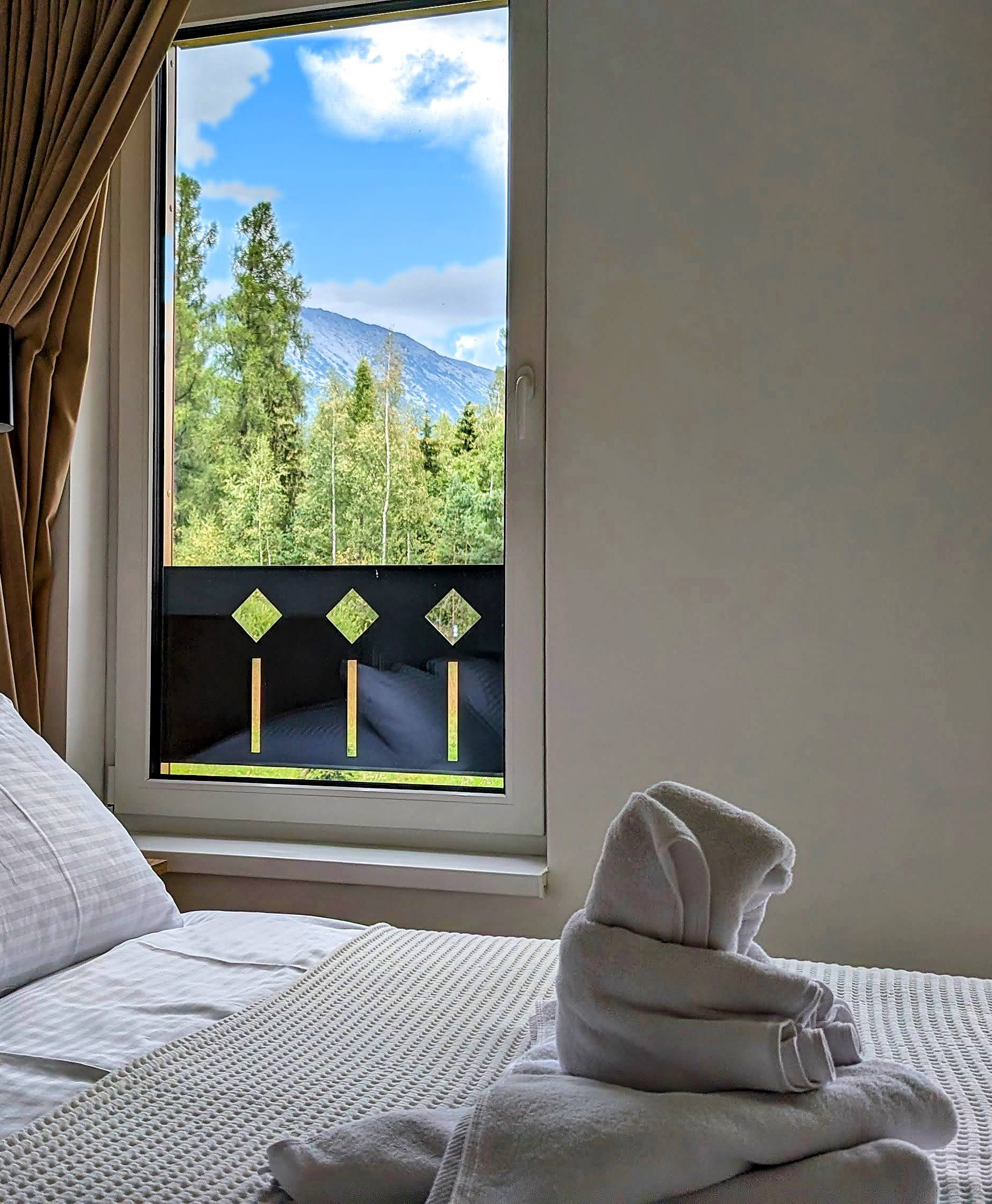 Posteľ pri okne s výhľadom na Tatry