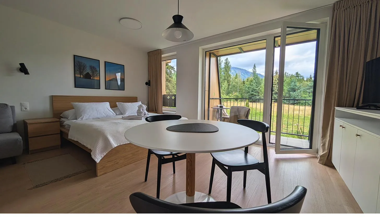 Apartmán s otvorenými balkónovými dverami a výhľadom na Tatry
