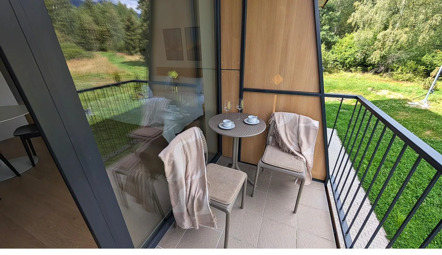 Balkón s bistro sedením a výhľadom do lesa